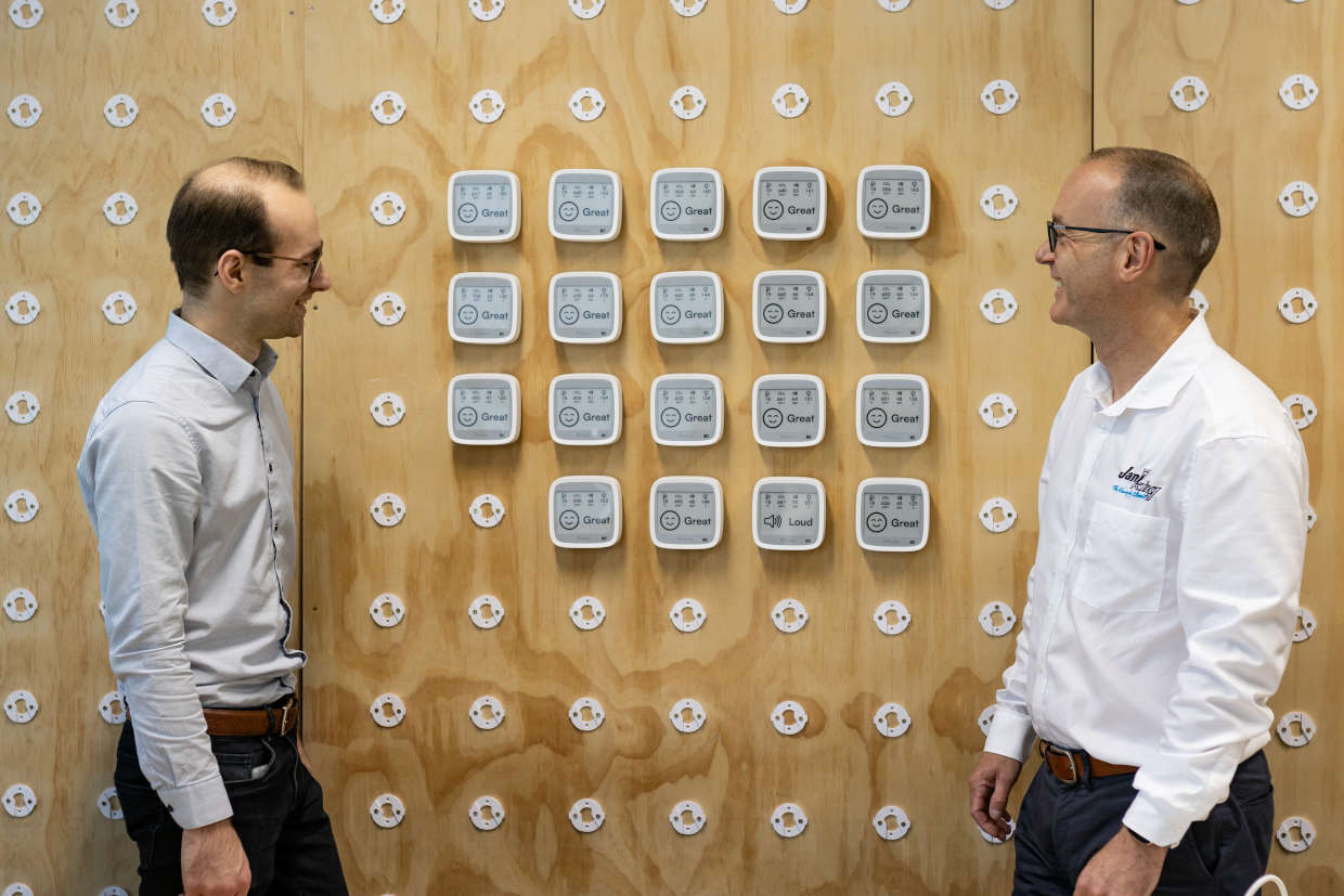 Andrew and Brad stand alongside a wall of AirSuite Glance sensors